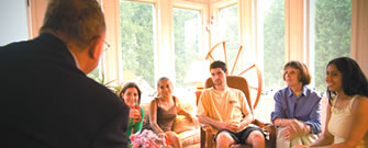 Students discuss the day's events at a faculty member's home.